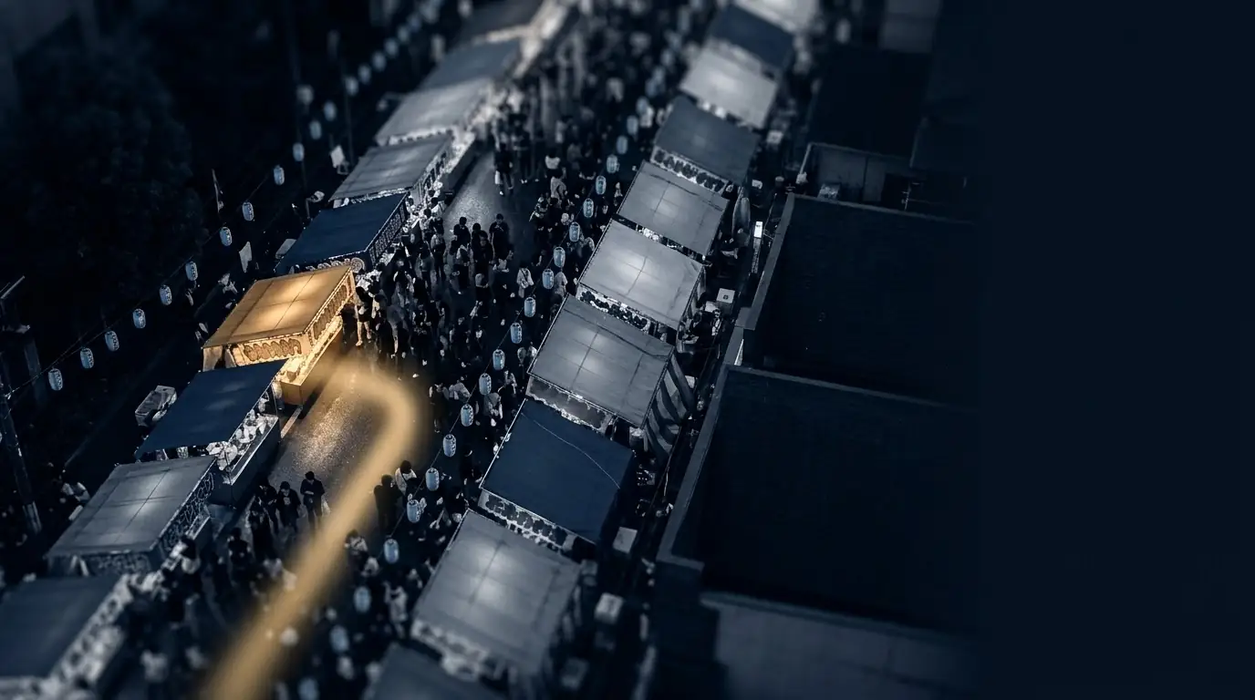 An aerial view of a night street of stalls with one stall glowing gold.