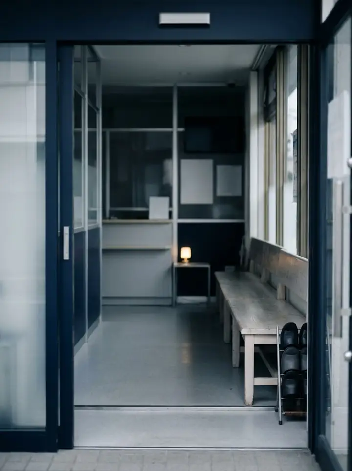 A quiet clinic waiting room with a wooden bench and a small warm lamp.